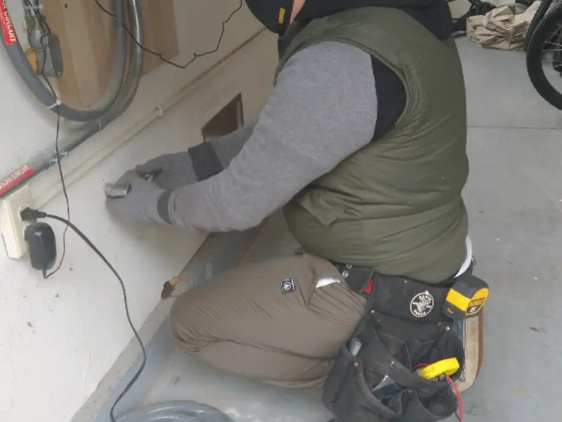 Electrician performing outlet wiring in a Summerville garage